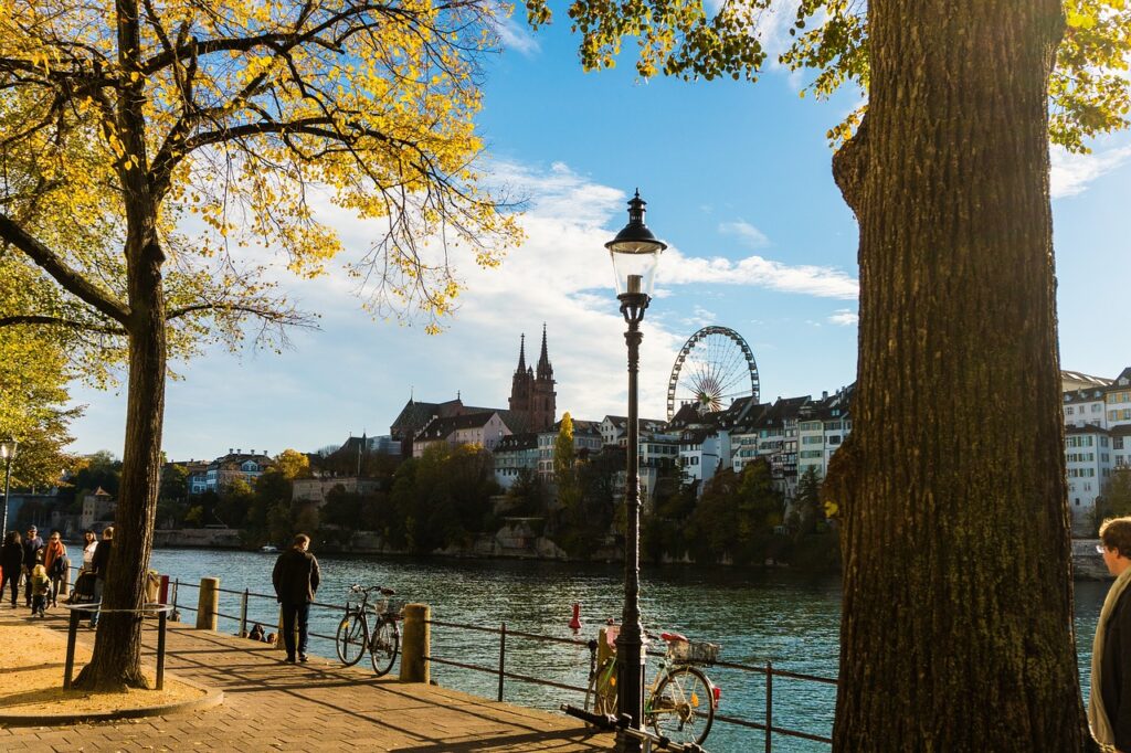 Basel Rheinufer Blick über den Fluss auf die Stadt Basel mit Riesenrad im Hintergrund