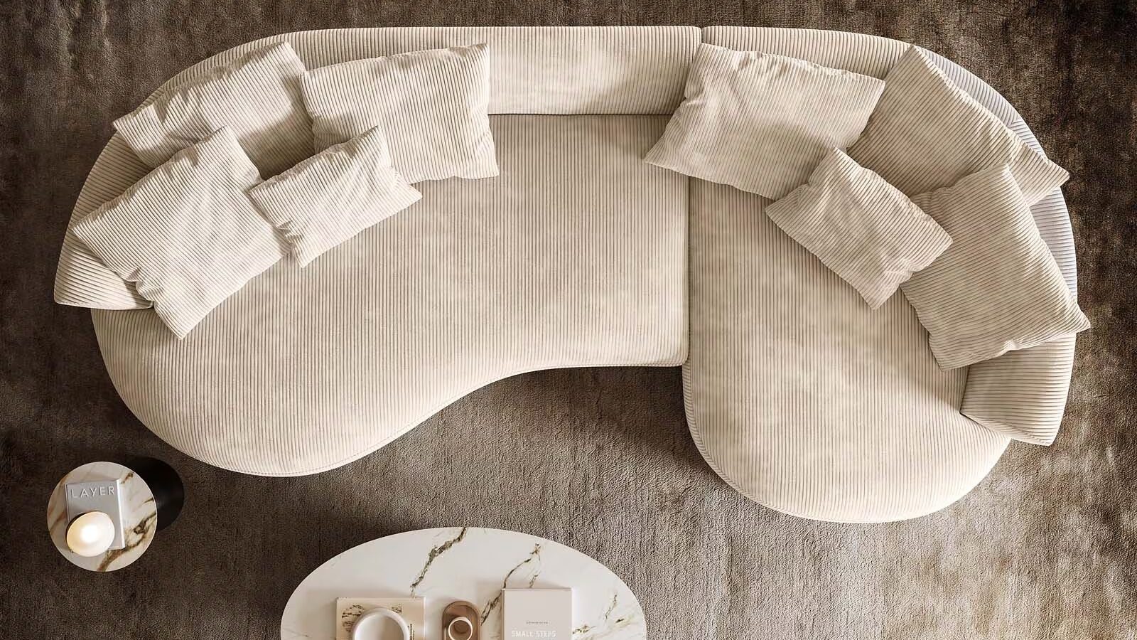 Draufsicht eines organisch geformten Sofas aus Cordstoff, das auf einem Teppich mit einem Coffee Table steht