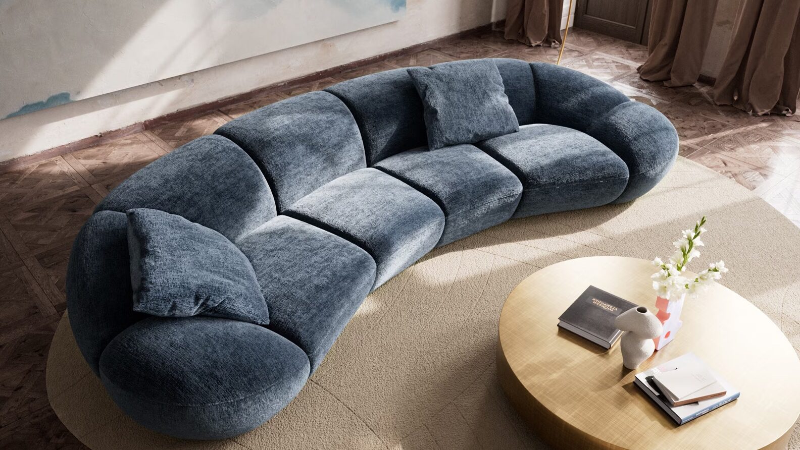 Sofa mit organischer Form in XXL steht auf einem Teppich mit einem Couchtisch, im Hintergrund sieht man Fenster und ein großes Kunstwerk an der wand